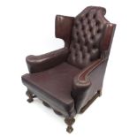 Brown leather wing back armchair with button back upholstery, 115cm high