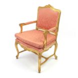 Gilt wood fauteuil, the toprail with carved shell motif, pink floral upholstery, 103cm high