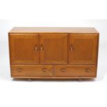 Ercol light elm sideboard fitted with three cupboard doors above two drawers, label to the interior,