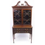 Chippendale style mahogany book case on stand, with swan neck pediment above a pair of astragal