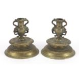 Pair of antique Venetian bronze candlesticks with grotesque twin handles and foliate engraving, each