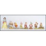 A collection of Royal Doulton Walt Disney Snow White & The Seven Dwarves figurines. Each being