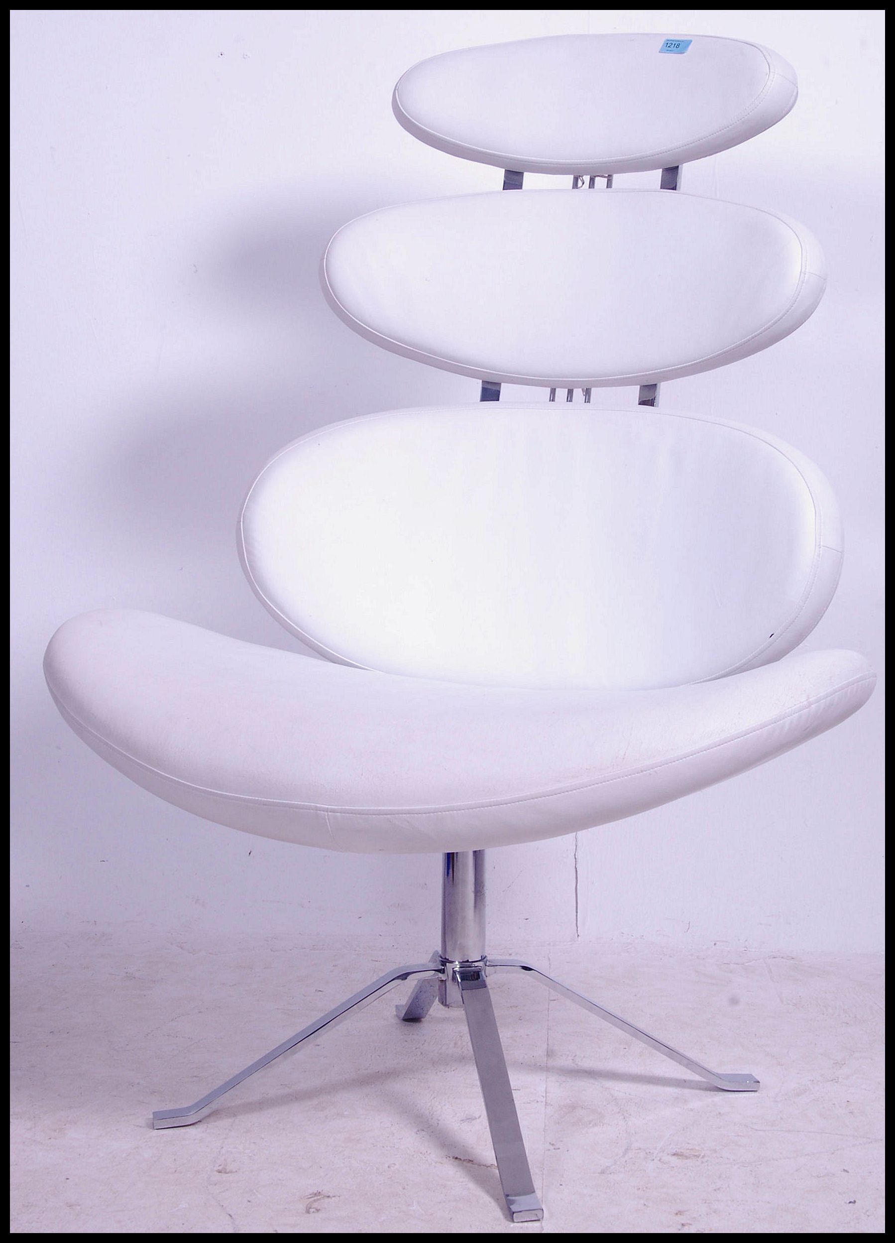 After Poul Volther. A `Corona` swivel lounge chair, with white vinyl upholstery to the pebble