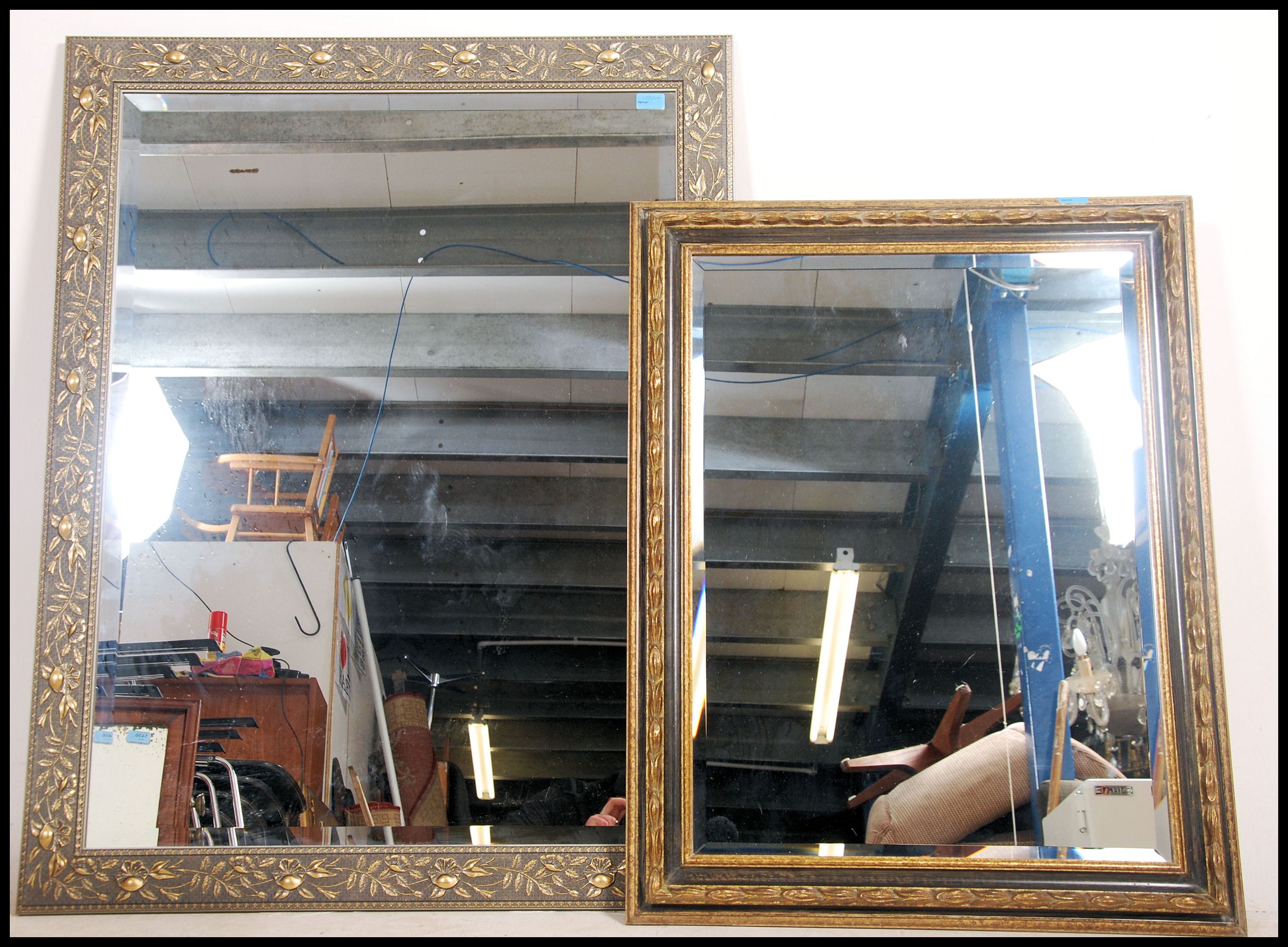 Two contemporary large framed mirrors the frames having  a gilt finish decoration with central