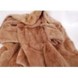A vintage 20th century ladies knee length fur coat ( possibly rabbit ) in a light golden colour. (