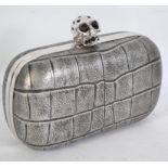 An Alexander McQueen faux crocodile faux leather clutch bag with skull detail clasp fastening,