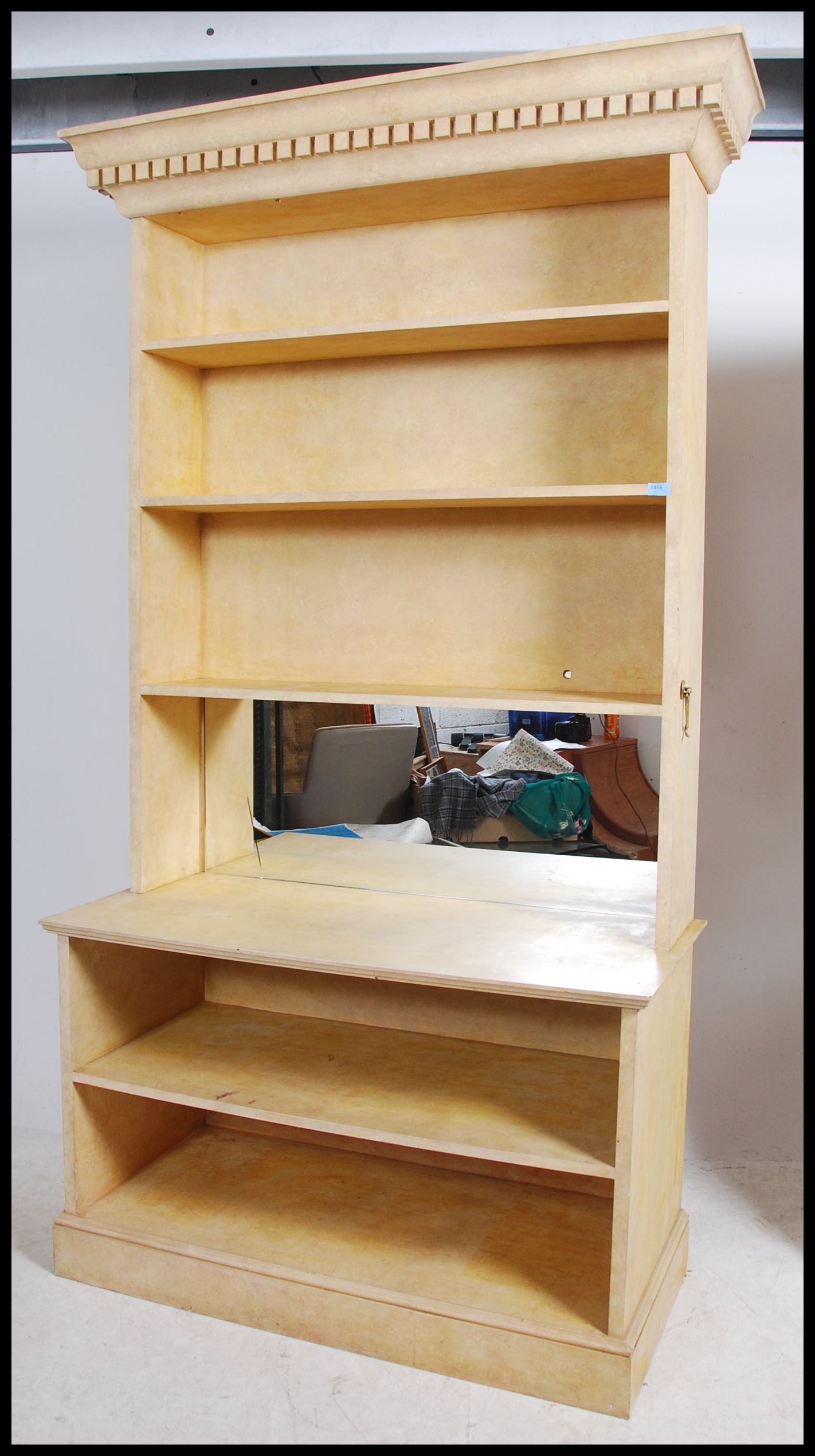 An unusual painted large breakfront bookcase cabinet having a flared cornice over open window