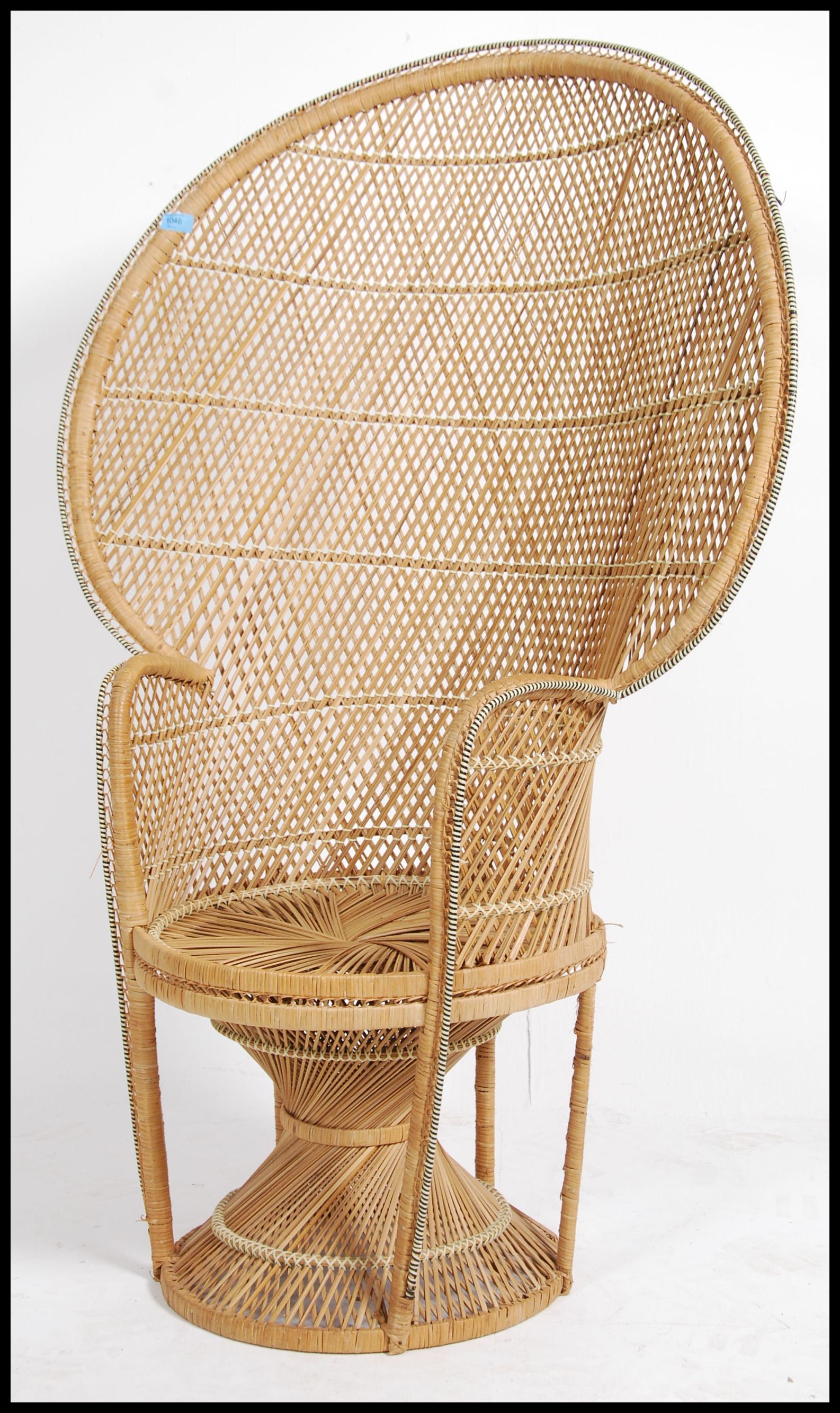 A vintage 20th century retro wicker peacock armchair with a large open back and woven seat. Measures