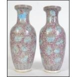 A pair of Chinese republic ceramic vases of famille rose design having purple and blue flower and