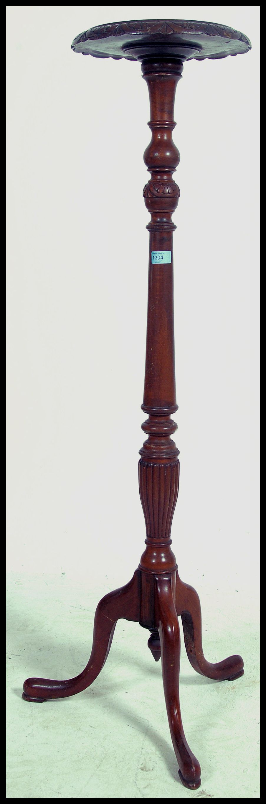 A 19th century mahogany torchere with reeded support raised on tripod feet.