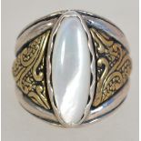 A silver 925 ladies oversized dress ring having central oval moonstone and textured yellow metal