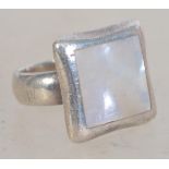 A silver 925 ladies dress ring having a mother of pearl square panel with silver border. Weighs 10.2