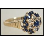 A 9ct gold hallmarked sapphire and diamond cluster ring. The central cluster mount adorned with