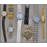 A group of watches to include a gold tone metal pocket watch with a fisherman to front, a Lorus
