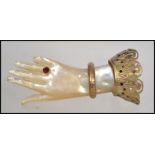A 19th century Victorian mother of pearl hand brooch with ruby ' Ring ' decoration adorned with gilt