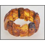 A vintage 20th century amber  plaque expanding bracelet, the plaques with inclusions