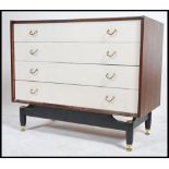 A 1970's retro teak and painted two tone G-Plan Librenza pattern chest of drawers being raised on an