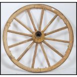 An early antique wooden cart wheel with iron hub and rim.  This wheel has had a lot of worm in the