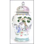 A large Chinese famille rose lidded vase decorated with scenes of peony tree's and birds with finial