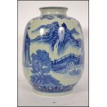 A Chinese blue and white kang-xi style vase with scenes of mountains and villages, the vase of