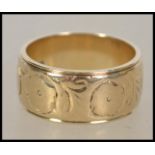 A hallmarked 9ct gold band ring having chased decoration. Bearing Birmingham assay marks, marked