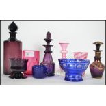 A collection of vintage glass dating from the 19th century to include purple decanters, blue glass