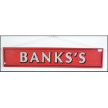 A vintage 20th century Banks Brewery enamel metal sign having white lettering on a red background.