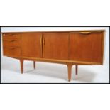 A 1970's retro Danish inspired teak wood sideboard dresser being raised on tapered supports having a