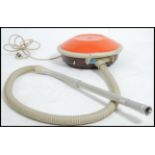 A vintage retro Hoover atomic flying saucer vacuum cleaner in a two tone finish of brown and orange.