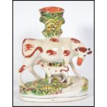 A Victorian Staffordshire ceramic spill vase flat back. The figurine diorama depicting a cow and