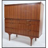 A 1970's retro teak wood - afromosia sideboard bureau having a fall front top with appointed