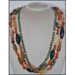 A green jade bead necklace having a barrel clasp along with a pale jade bangle bracelet and a