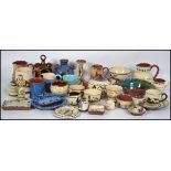 A large collection of Devon / Cornish torquay ware / mottoware ceramic pottery jugs and other