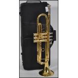 A cased 20th century brass trumpet with mother of pearl buttons. Inscribed Gear 4 Music to main