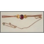 A 9ct gold Edwardian bar brooch having a central faceted red stone to center and c clasp pin back