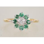 An 18ct gold emerald and diamond ring having cluster head with central diamond and emerald surround,