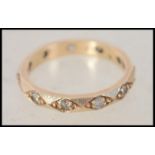 A 9ct gold and paste stone set eternity ring. The concentric stones being inset into lozenge