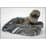 An Oriental green soapstone carving of a roaring t