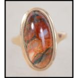 A 9ct gold and agate set ladies dress ring. The central elongated cabochon agate stone set to a