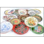 A large collection of mainly German studio pottery plates, most decorated with vibrant colours.