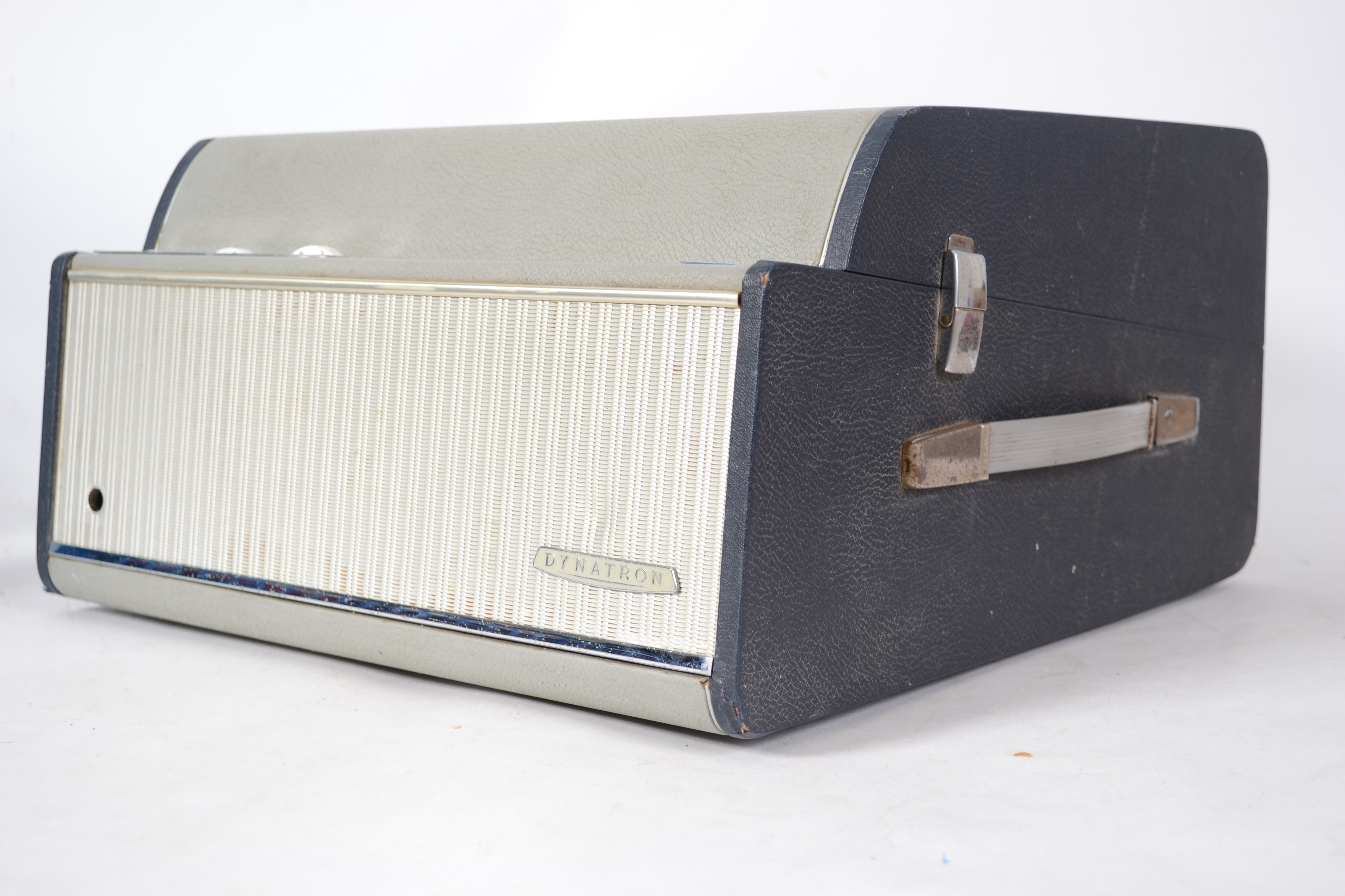 A vintage 20th century Dynatron four speed portable record player in a two tone finish. Carry handle