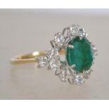 An 18ct gold, diamond and emerald cluster ring. Th