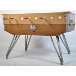 A 1970's retro  large table football foosball game. Raised on large cast metal hairpin legs with
