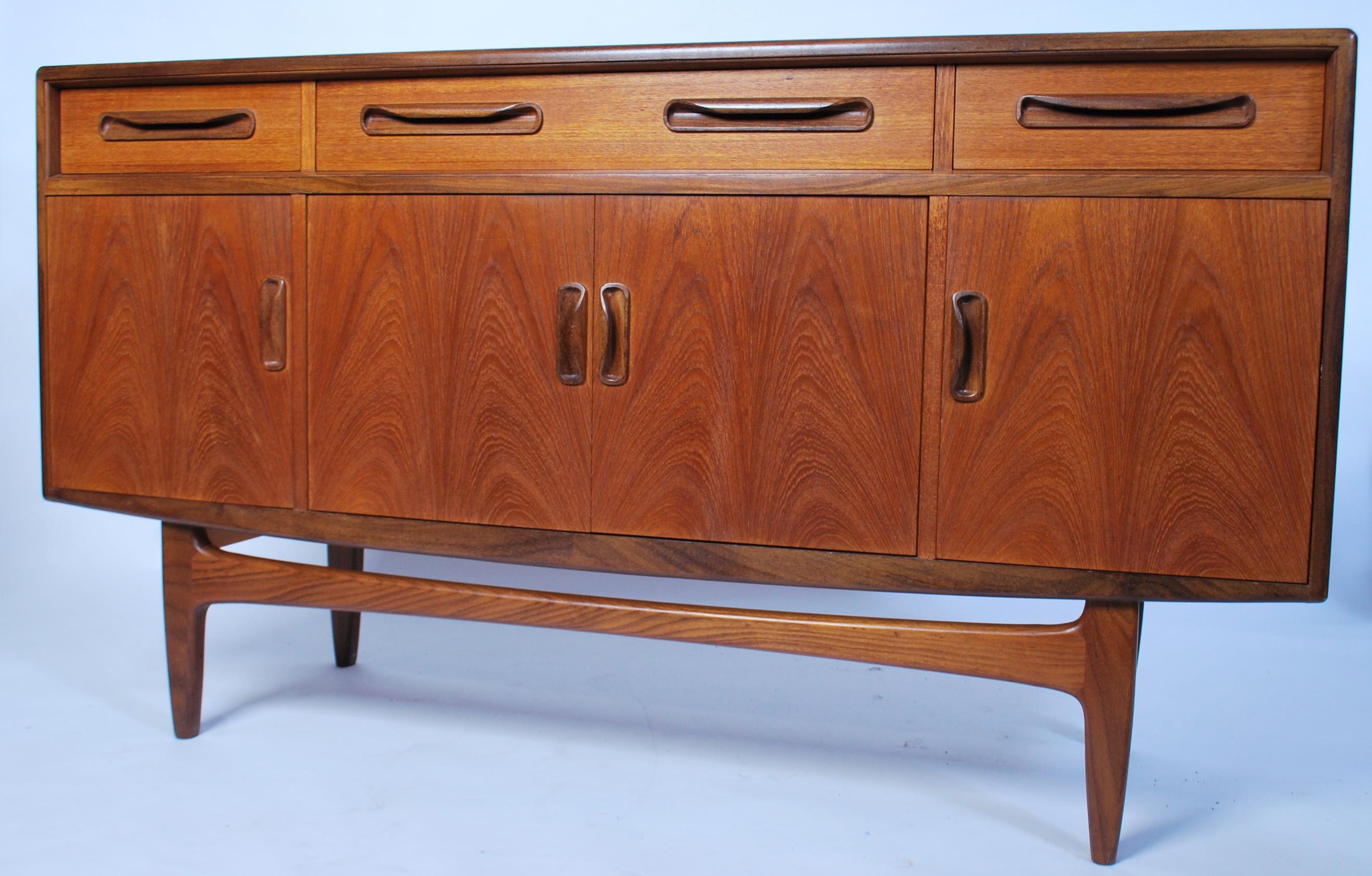 A 1970's retro G-Plan ' Fresco ' pattern teak wood sideboard being raised on tapered supports having