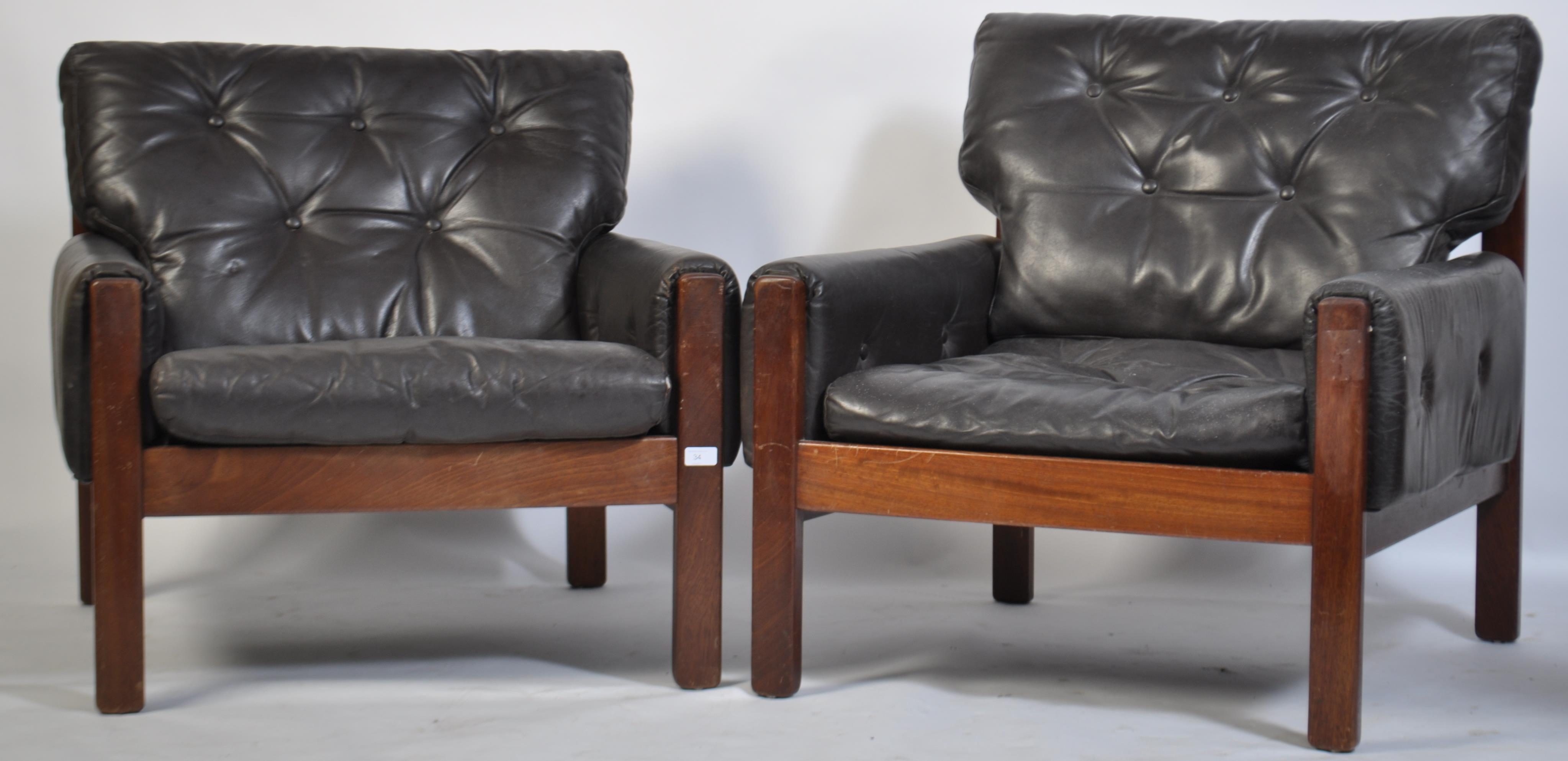 A stunning pair of 1960's teak and leather Danish armchairs. The black leather cushions being button