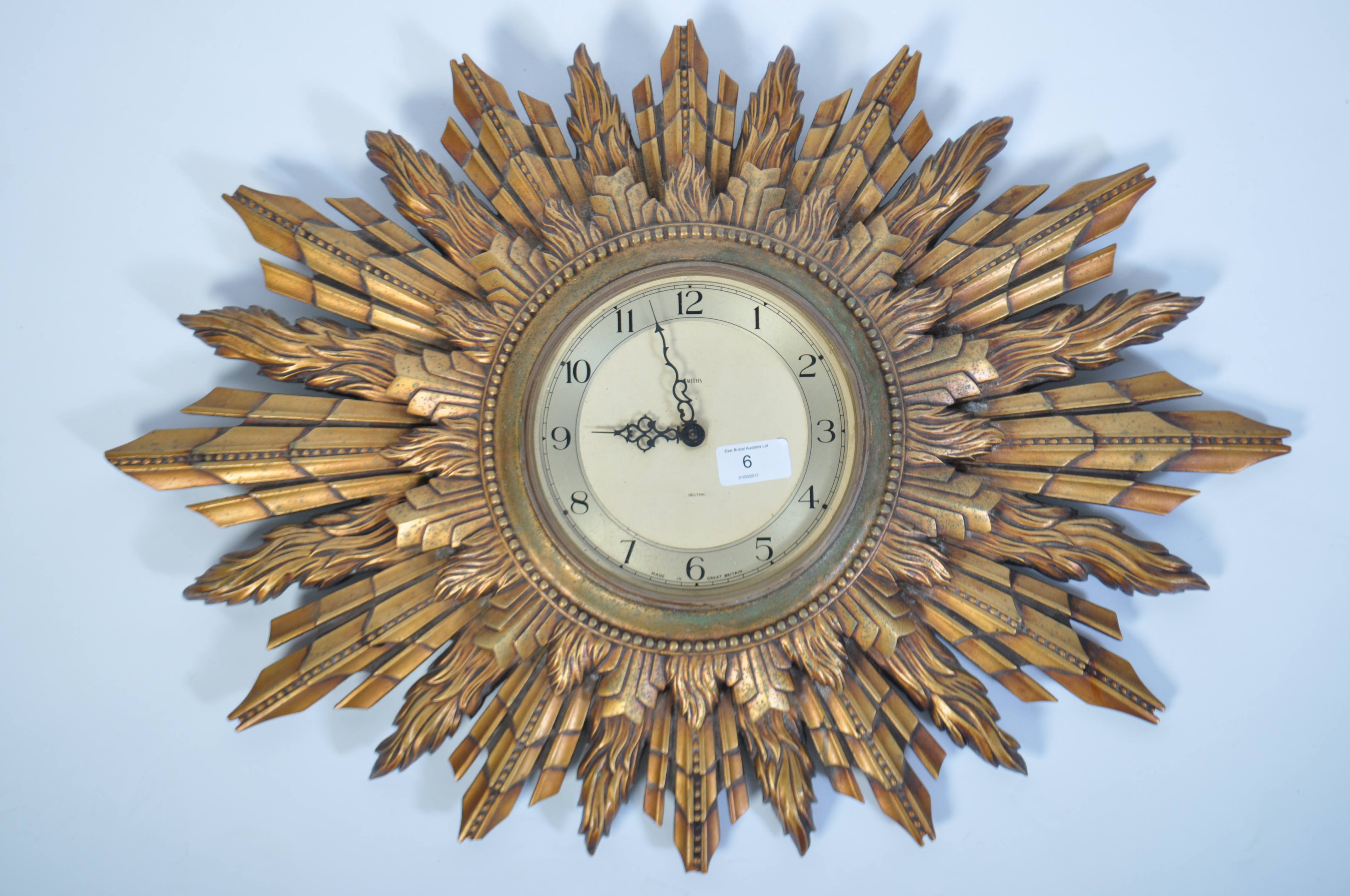 An early 20th century Smiths Electric sunburst wall clock having original electric movement with all