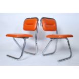 A pair of 1970's retro chrome tubular orange vinyl upholstered dining chairs. Raised on stunning