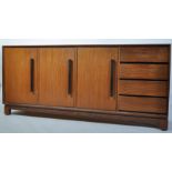 A 1960's Danish teak sideboard dresser of large proportions being raised on a teak suspension set