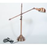 A fabulous polished copper anglepoise desk lamp raised on terraced base with tubular construction