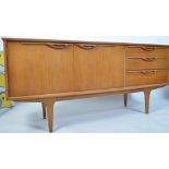 A 1970's teak wood Danish inspired sideboard of small proportions having tapered legs with a